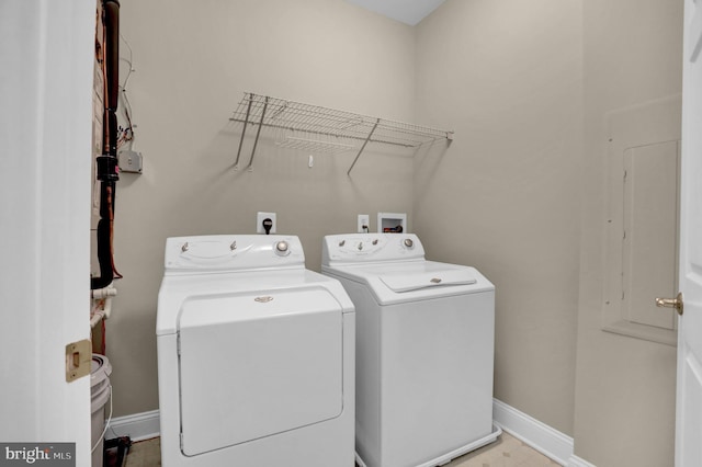 washroom featuring laundry area, washer and clothes dryer, and baseboards