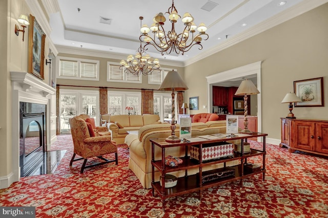 living room featuring visible vents, a raised ceiling, an inviting chandelier, carpet, and crown molding