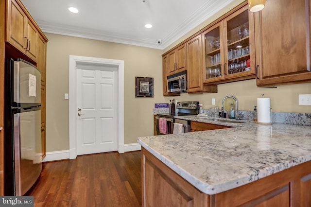 kitchen with brown cabinetry, stainless steel appliances, and crown molding