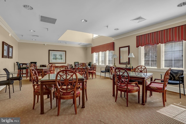 carpeted dining room featuring ornamental molding, visible vents, and baseboards