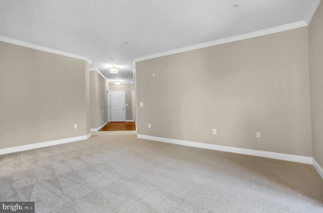 unfurnished room with ornamental molding, carpet flooring, and baseboards