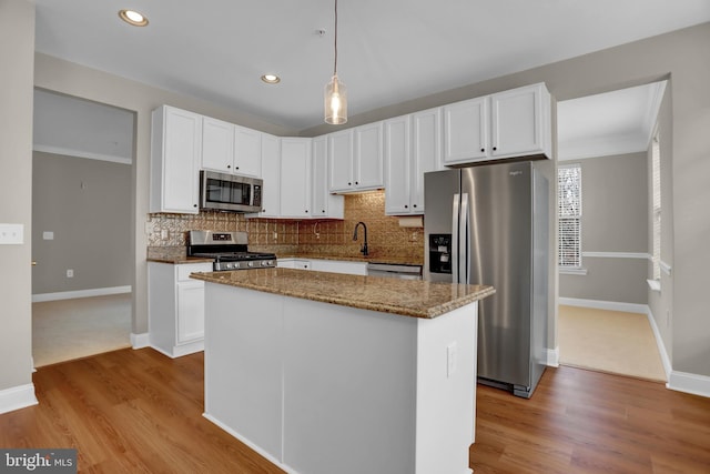 kitchen with tasteful backsplash, white cabinetry, and stainless steel appliances