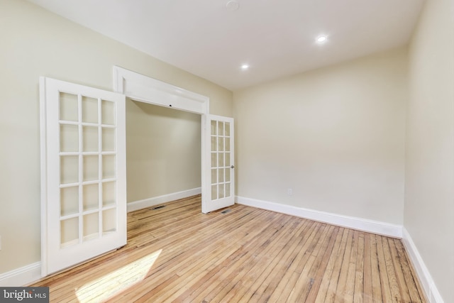 empty room featuring light wood-style floors, baseboards, and recessed lighting