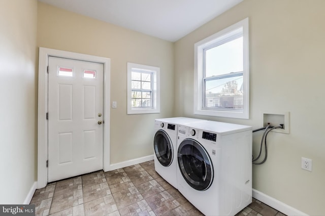 clothes washing area featuring laundry area, baseboards, and washing machine and clothes dryer