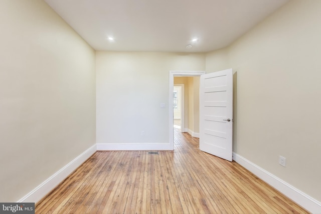 unfurnished room with light wood-type flooring and baseboards