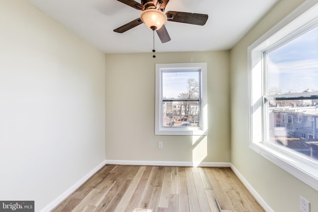 unfurnished room featuring light wood finished floors, a ceiling fan, and baseboards