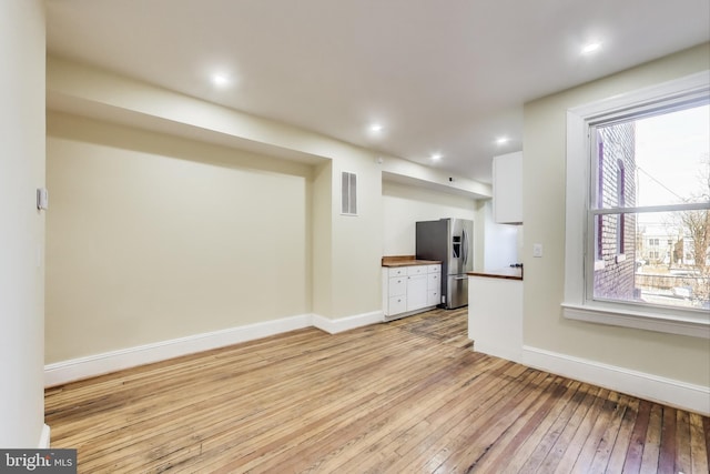 unfurnished living room featuring recessed lighting, light wood-type flooring, visible vents, and baseboards