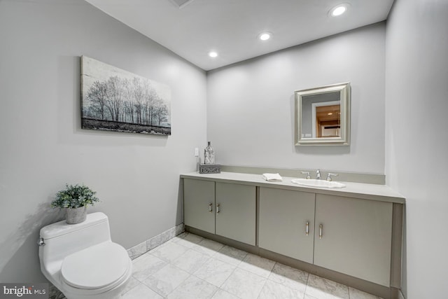 bathroom with toilet, recessed lighting, baseboards, and vanity