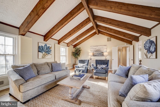 living area featuring vaulted ceiling with beams, visible vents, and baseboards