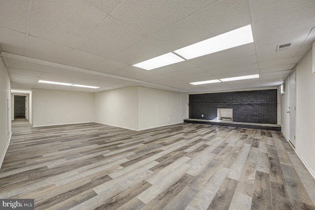 spare room featuring baseboards, visible vents, a drop ceiling, and wood finished floors