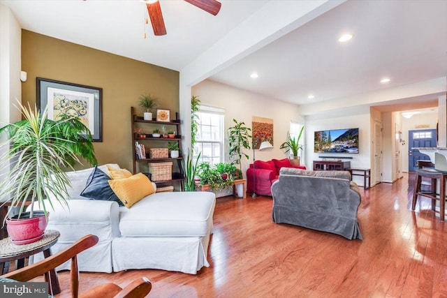 living area with light wood-type flooring, ceiling fan, beamed ceiling, and recessed lighting