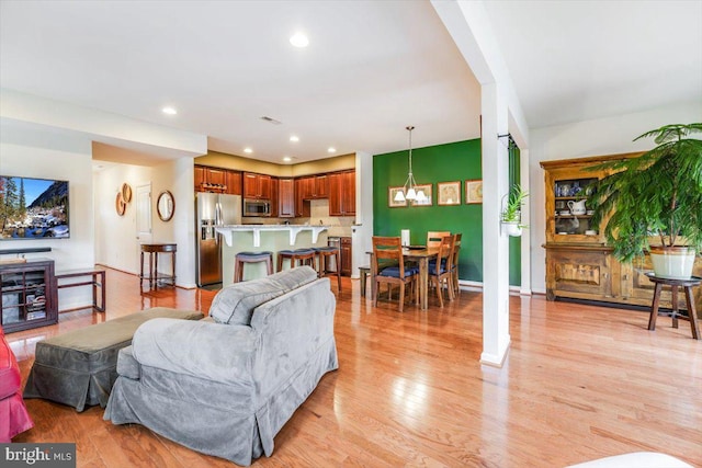 living room featuring baseboards, light wood-type flooring, and recessed lighting