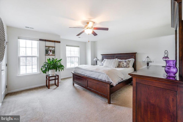 bedroom with light colored carpet, visible vents, ceiling fan, and baseboards