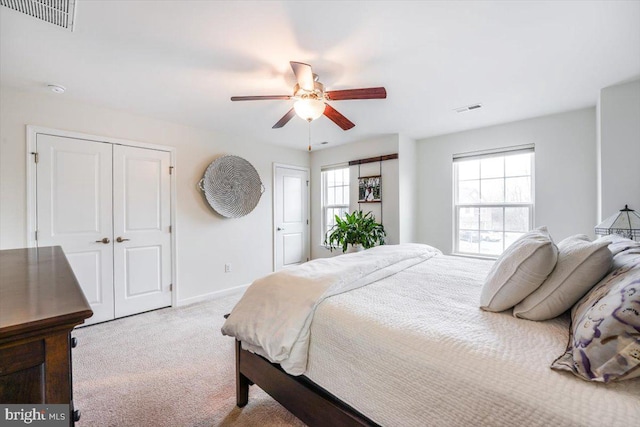 bedroom featuring light carpet, multiple windows, and visible vents