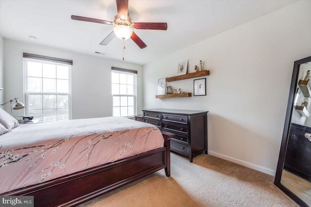 bedroom featuring light carpet, a ceiling fan, visible vents, and baseboards