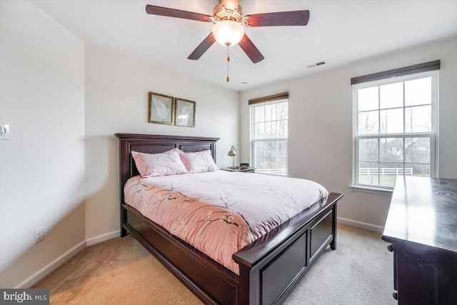 bedroom featuring baseboards, visible vents, and light colored carpet