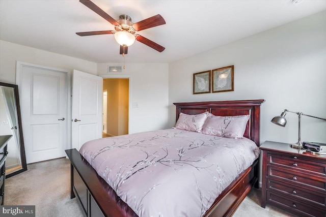 bedroom with light carpet, visible vents, and a ceiling fan