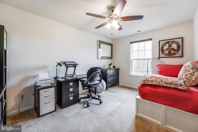 office space featuring a ceiling fan, light colored carpet, visible vents, and baseboards