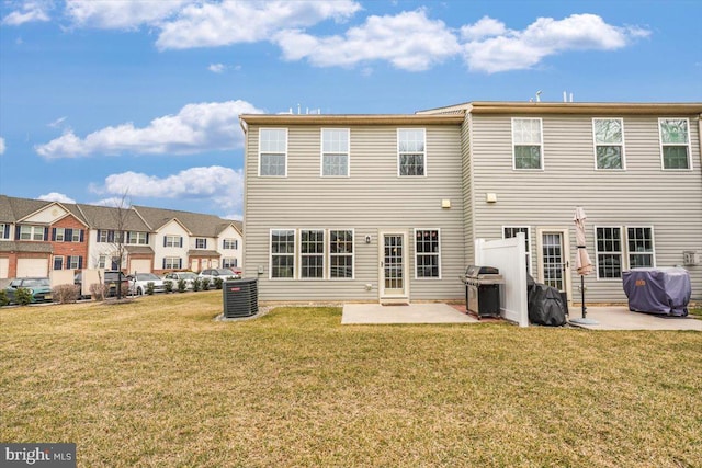 back of house featuring cooling unit, a patio area, and a lawn