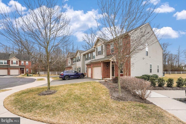 view of home's exterior featuring driveway, an attached garage, fence, and brick siding