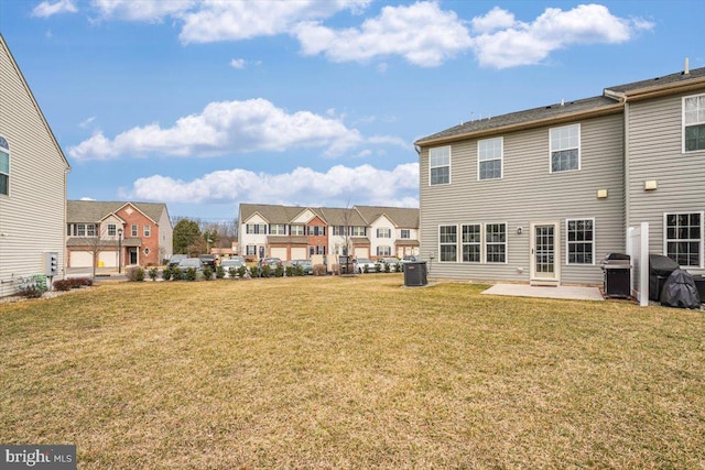 back of house featuring a residential view, a patio area, and a lawn