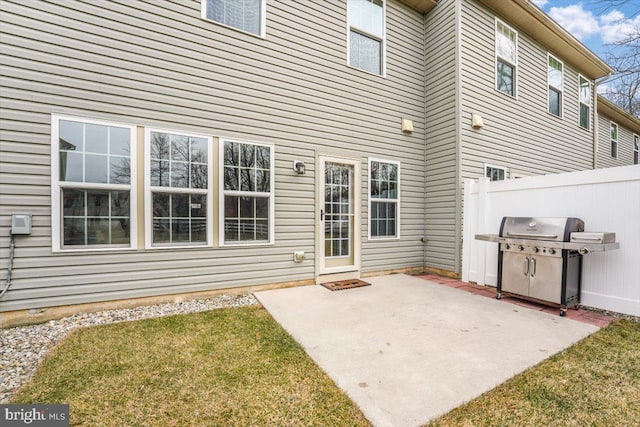 rear view of property featuring a patio area, fence, and a lawn