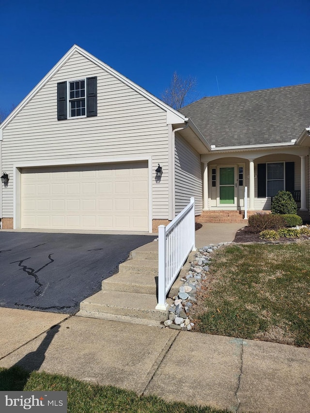 view of front of property with driveway, a shingled roof, and brick siding