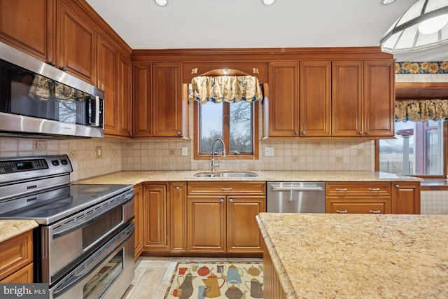 kitchen featuring a healthy amount of sunlight, appliances with stainless steel finishes, decorative backsplash, and a sink