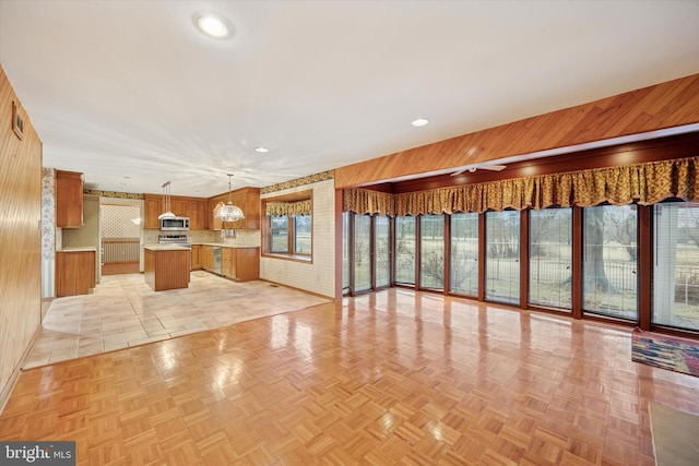 unfurnished living room with wooden walls and recessed lighting