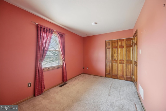 carpeted spare room with baseboards and visible vents