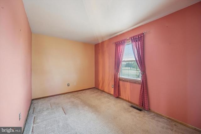 spare room with visible vents, light carpet, and baseboards