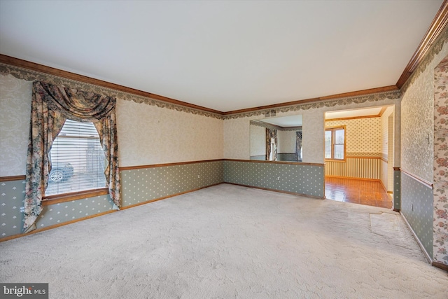 empty room with a healthy amount of sunlight, wallpapered walls, carpet, and crown molding