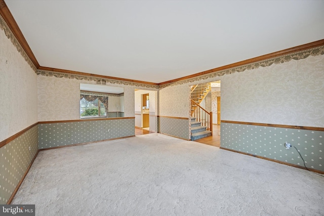 unfurnished room with stairs, crown molding, carpet, and wallpapered walls