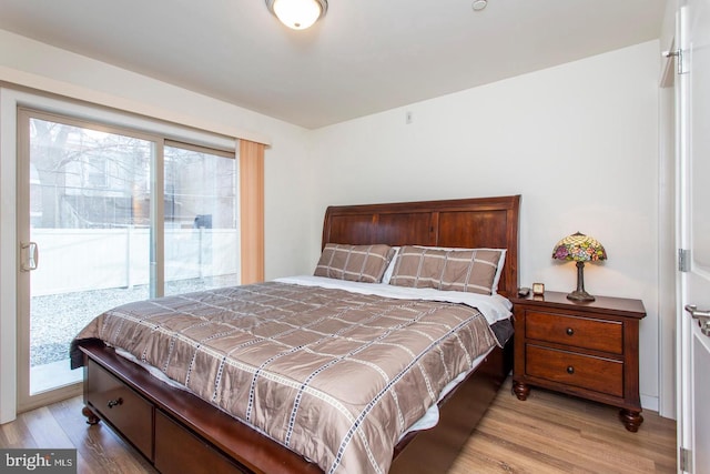 bedroom with light wood-style floors and access to outside