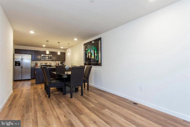 dining area featuring baseboards, visible vents, wood finished floors, and recessed lighting