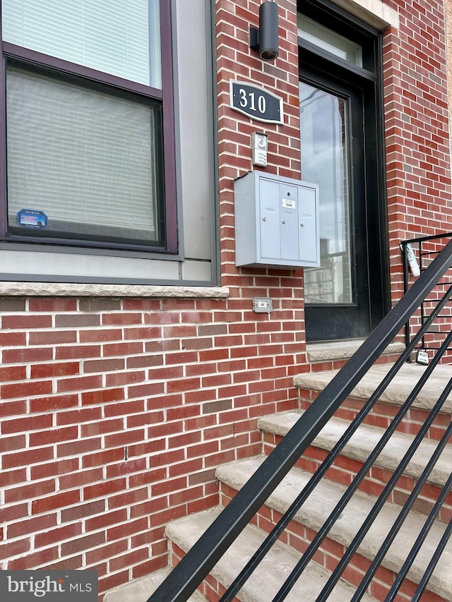 doorway to property with brick siding