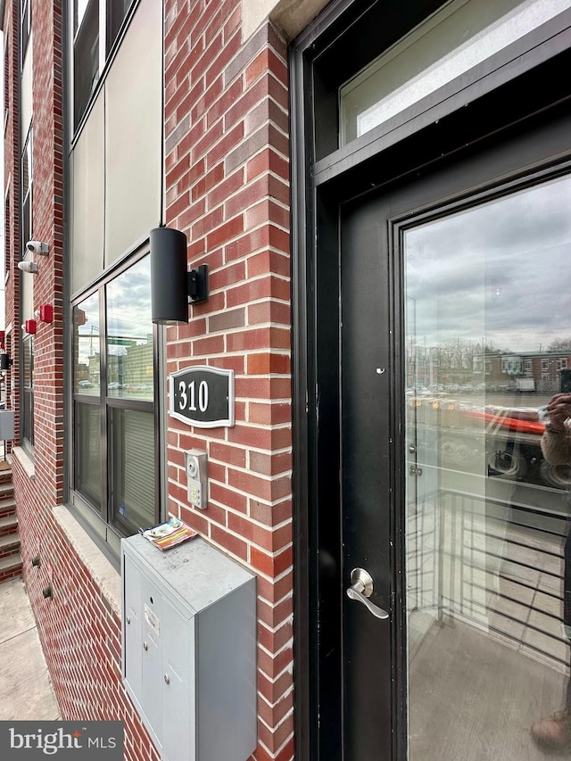 doorway to property featuring brick siding