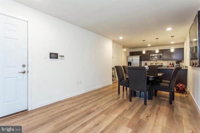 dining room featuring recessed lighting, light wood-style flooring, and baseboards