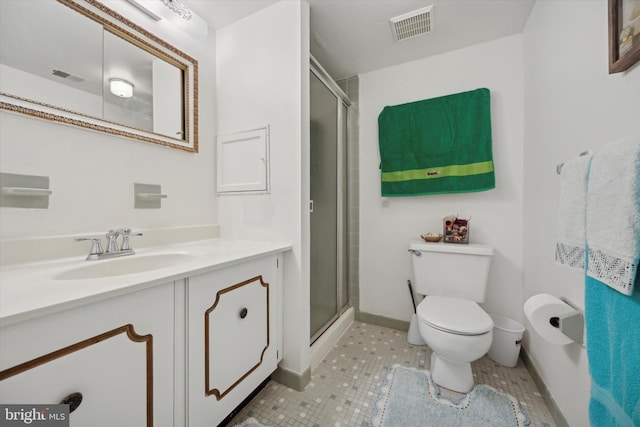 bathroom featuring tile patterned flooring, vanity, toilet, and a shower with door