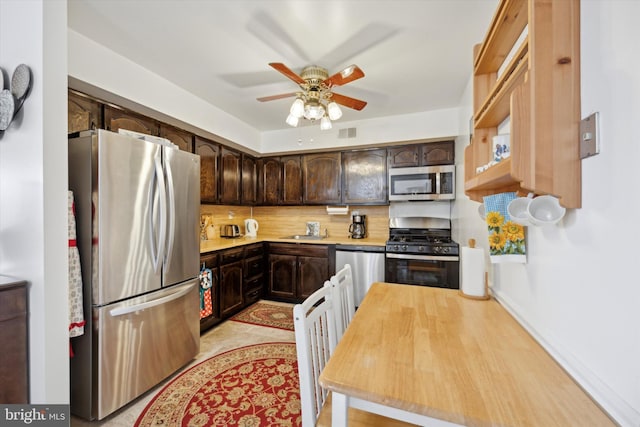 kitchen featuring stainless steel appliances, sink, dark brown cabinets, ceiling fan, and decorative backsplash