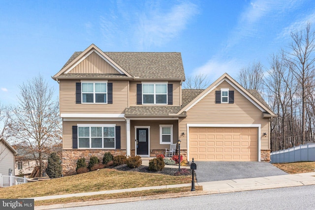 craftsman-style home with driveway, stone siding, an attached garage, and roof with shingles