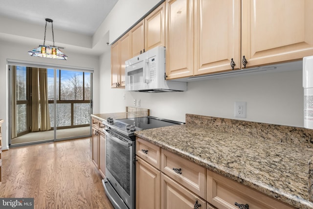 kitchen with white microwave, light wood-style flooring, light brown cabinets, and stainless steel range with electric stovetop