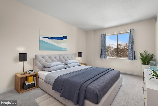 bedroom with baseboards and light colored carpet