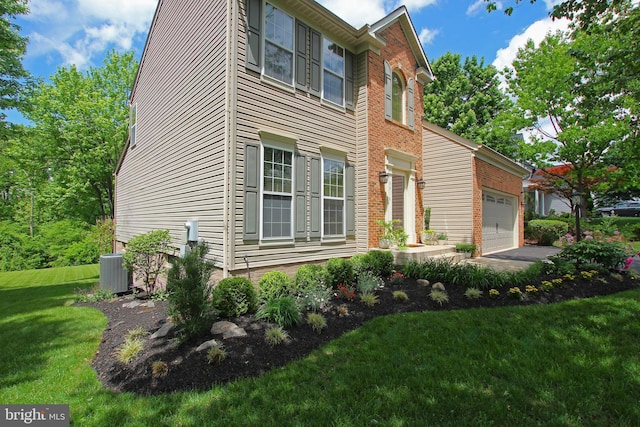 15516 Wigeon Way, Woodbridge, VA 22191 - view of property exterior featuring a lawn, a garage, and central AC