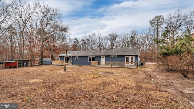 rear view of property with a shed and a deck