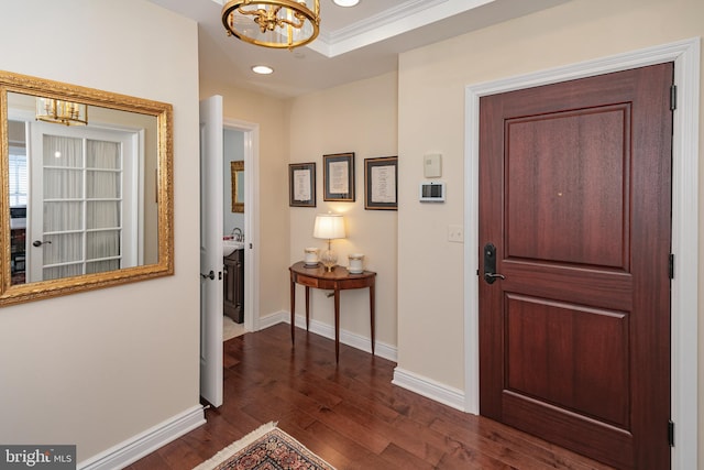 entryway featuring baseboards, dark wood-style flooring, crown molding, a notable chandelier, and recessed lighting