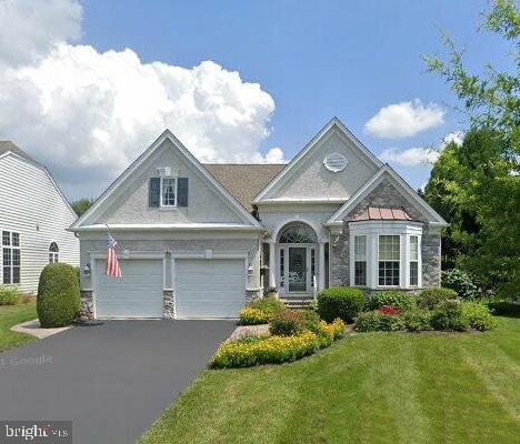 view of front of property featuring an attached garage, driveway, and a front yard