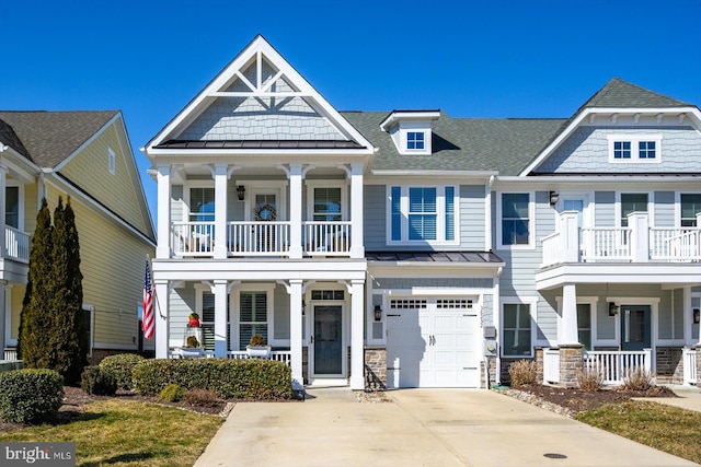 view of front of house with a garage, concrete driveway, metal roof, a standing seam roof, and a porch