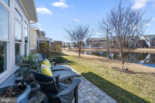 view of yard with a residential view, a patio area, and a water view