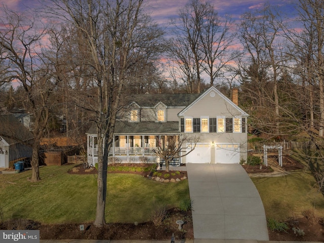 view of front facade with a yard, covered porch, and a garage